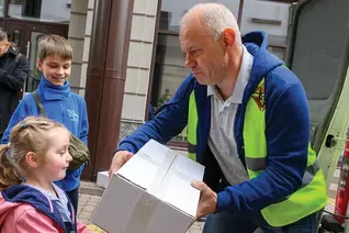 Myroslav Mazur, a member of Andrey Sheptytsky Council 15804 in Ivano-Frankivsk, Ukraine, hands a care package to a girl
