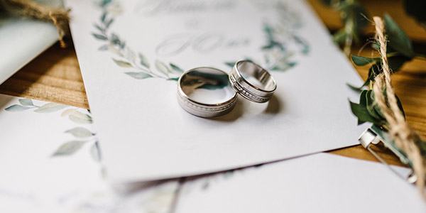 wedding rings on top of invitations