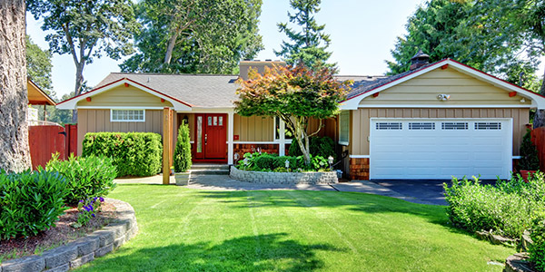 A nice wood and vinyl house with dark yellow walls, red trim, and a bright red door