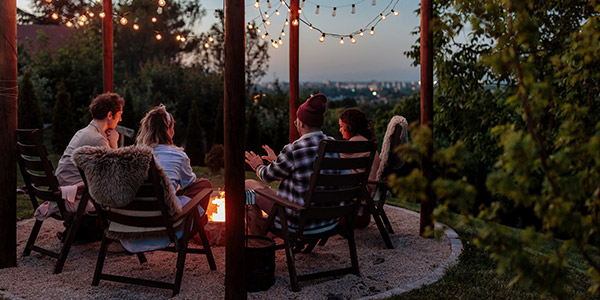 friends sitting around a firepit at night