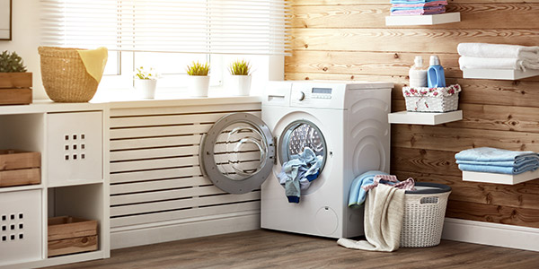 an open dryer sits in a tidy and well lit laundry room