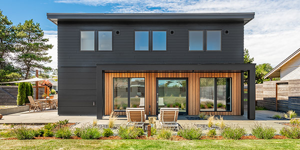 a black modern home with a secondary building beside it