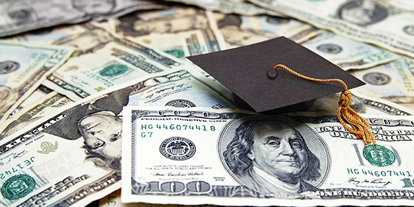 graduation cap laying on top of cash