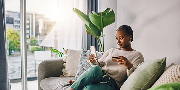 woman on her phone holding a credit card