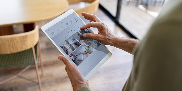 woman looking at security feed on a tablet