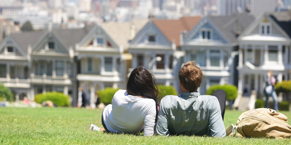 couple on the grass staring at houses