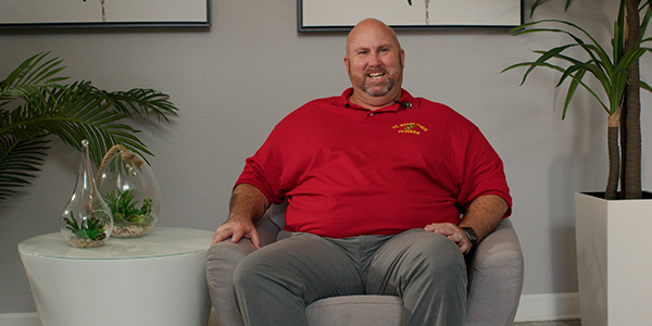 Man in a red shirt sitting in a chair