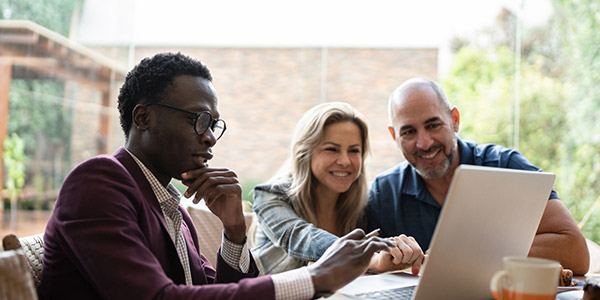 agent with clients looking at a laptop