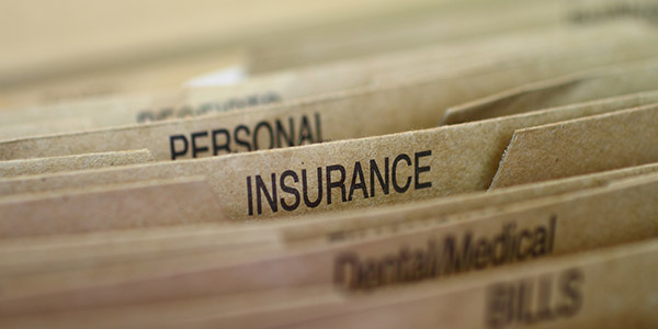 The inside of a a filing cabinet with folders marked insurance and personal 