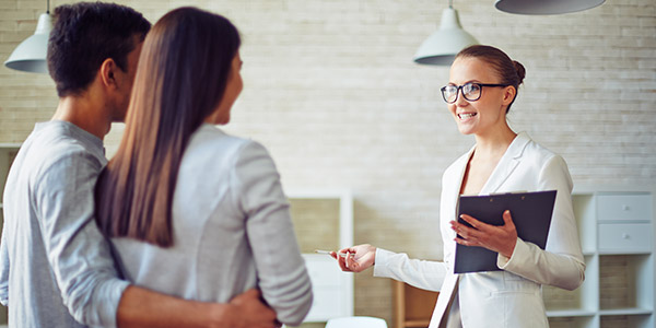 real estate agent with homebuyers at a house showing