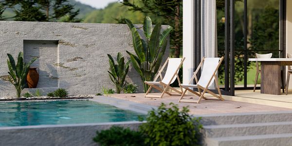 An outdoor pool surrounded by a grey stone patio 