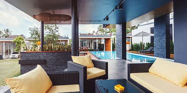 An nice outdoor patio with a pool and stone patio 