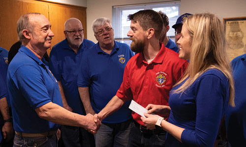 After helping the Ampe family pack medical supplies to bring to Ukraine, members of Father Vincent L. Ouellette Council 1541 present Joe and Tiffany with a donation of financial support.