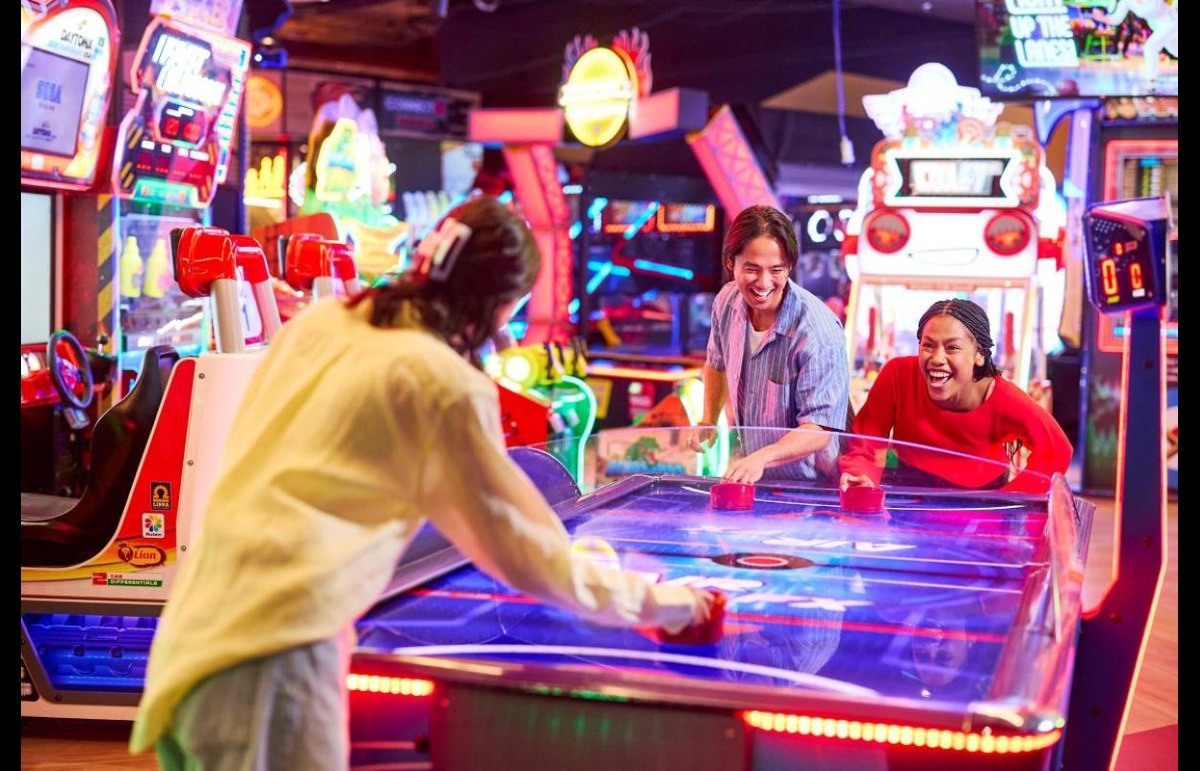 Friends playing air hockey at Timezone