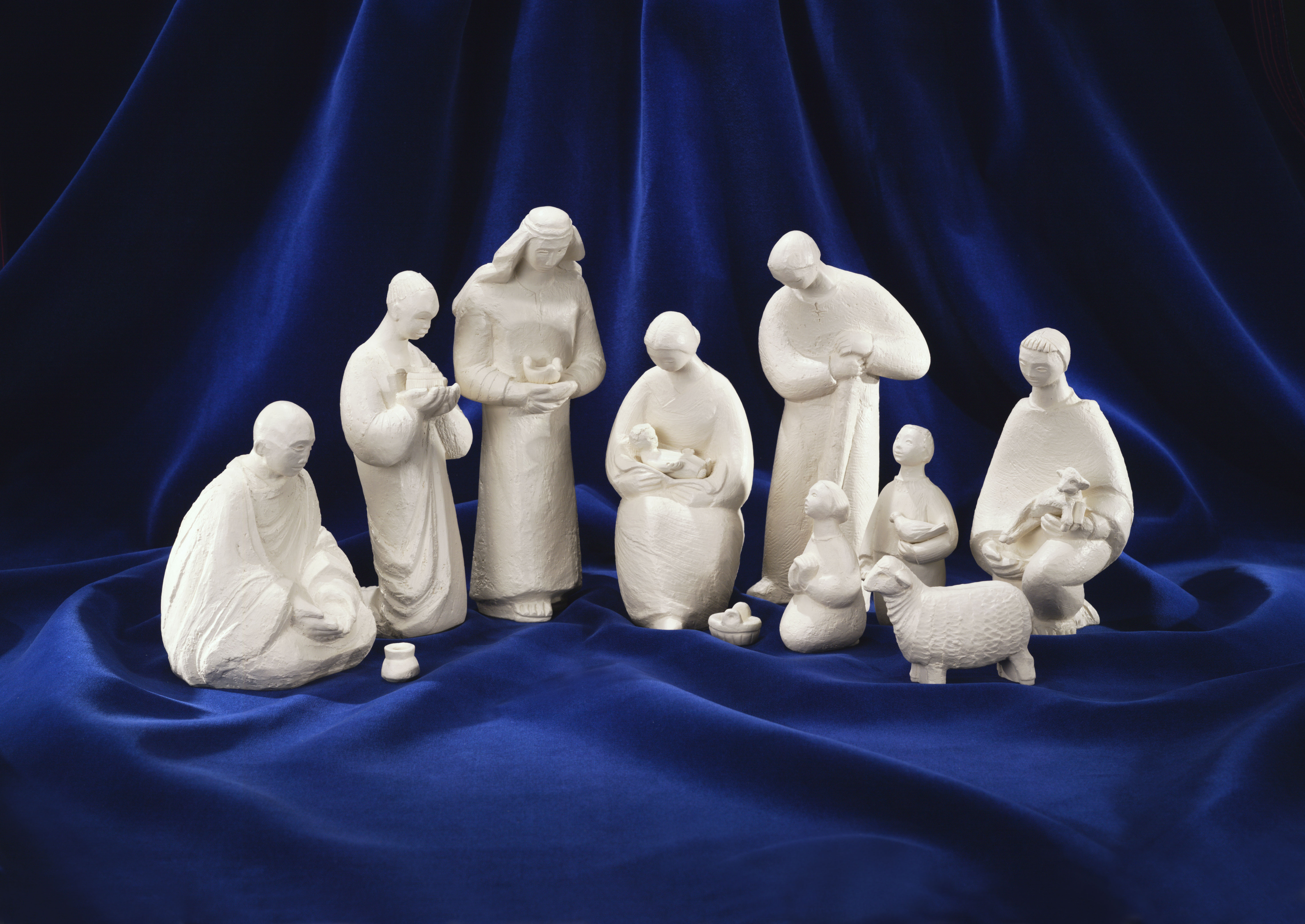 White cement Nativity scene featuring figurines of Holy Family, 3 Magi, a shepherd, two children, and a sheep.