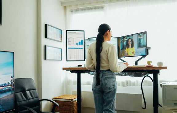 Woman working at a standing desk and walking on a treadmill