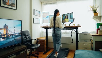 Woman working at a standing desk and walking on a treadmill
