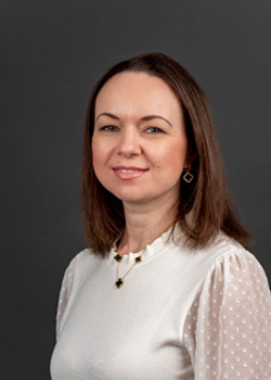 Headshot of Yulia Krayter, who smiles while wearing a white blouse