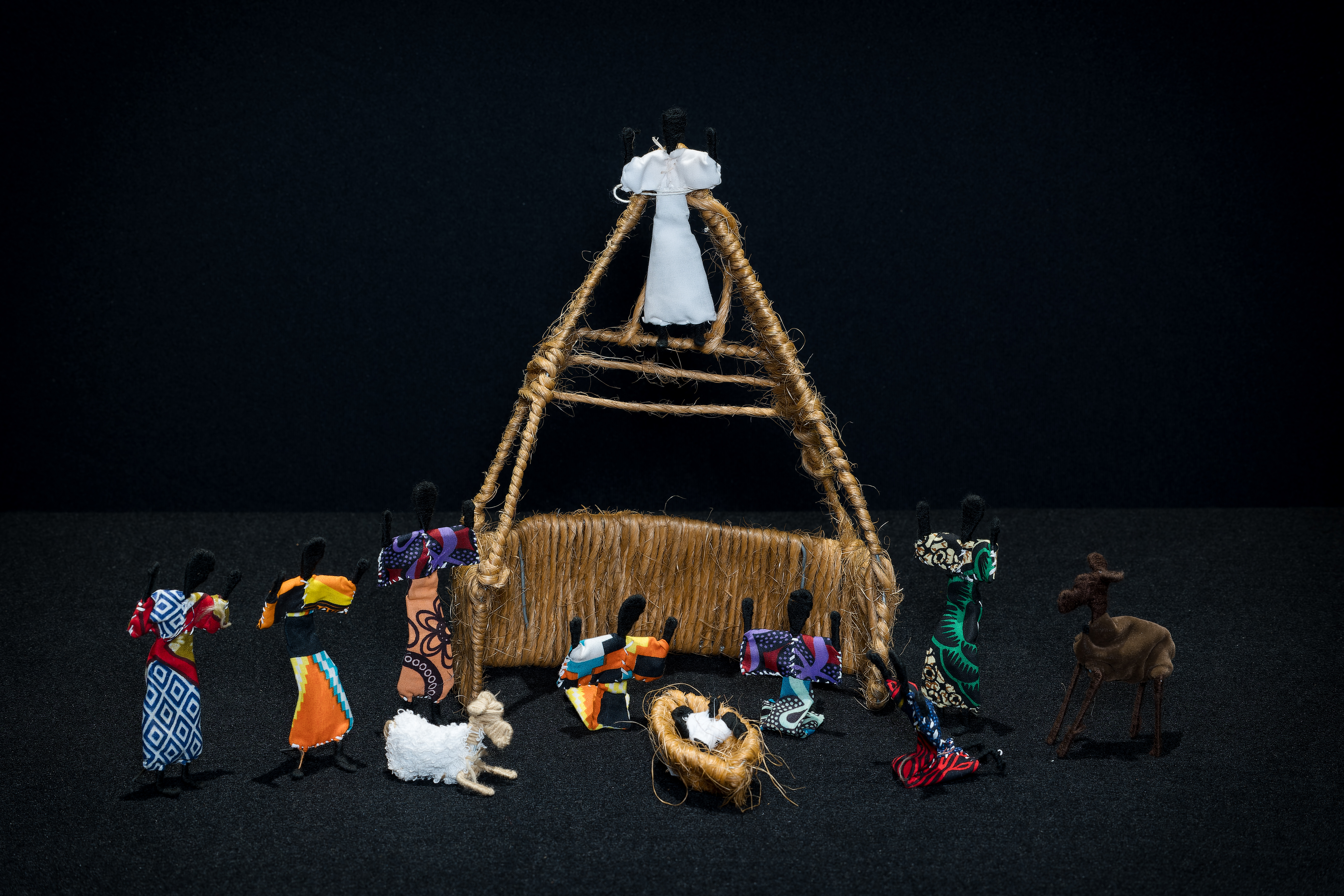 Nativity scene which includes the Holy Family and numerous onlookers in colorful clothing.