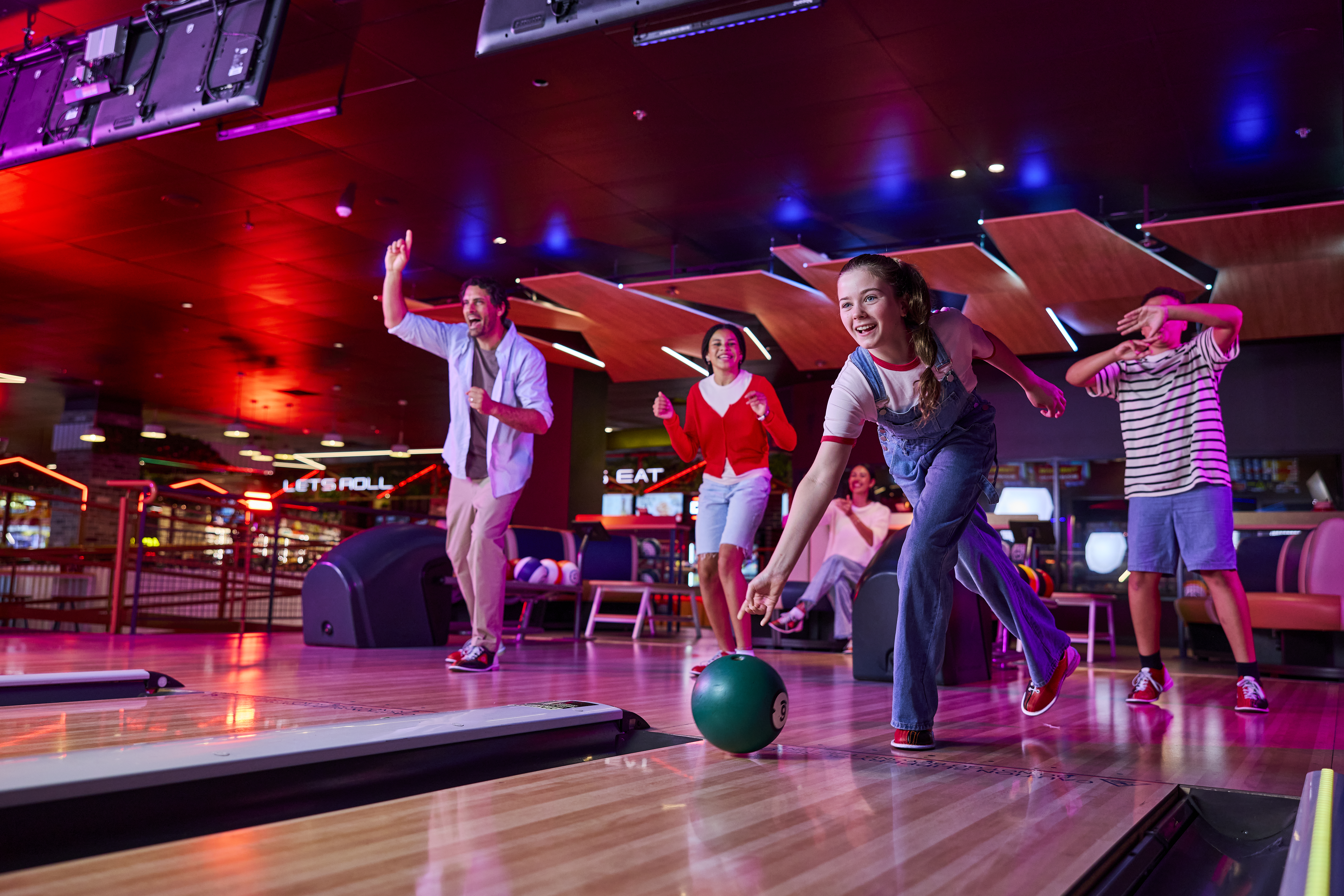 Family bowling and playing games at Zone Bowling